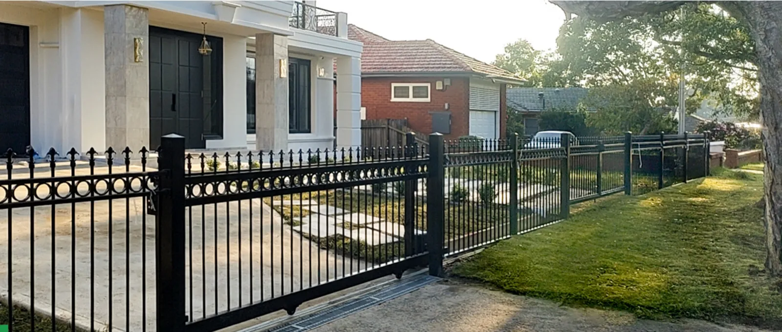 Black aluminum spear-top fence and gate in front of a heritage building